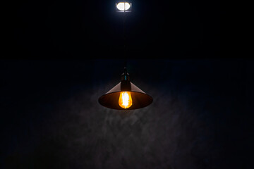 Lamp bulb with light on the ceiling and a selection with black appropriate the background , idea...