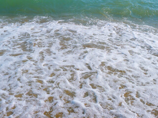 Foam after a splash of a powerful sea wave, natural liquid abstract background, marine concept