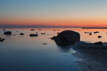 Fototapeta na wymiar Boulders on the coastal sunset. Long exposure.