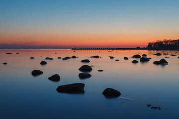 Boulders on the coastal sunset. Long exposure.