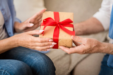 Present of love. Senior couple sharing holiday gift