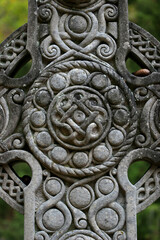 Intricately carved gravestone with Celtic cross and pinecone detail