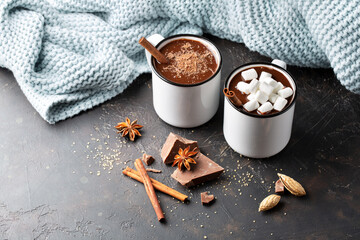 Hot chocolate with marshmallow and cinnamon stick on brown background