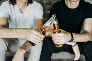 Two Stylish Twins Brothers Having Fun Drinking Beer on the Stairs