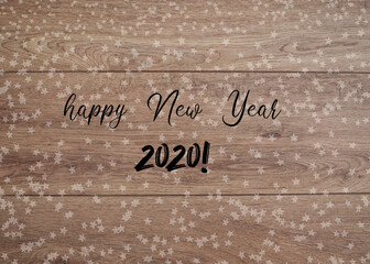 New Year card. The text "hapy New Year 2020" on the wooden background with little white stars.