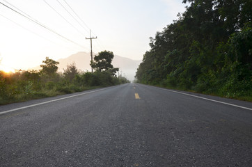 Quiet Country Road with Green Natural Forest and Mountain