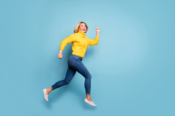 Fototapeta na wymiar Full length profile photo of crazy lady jumping high rushing shopping center black friday sale wear knitted yellow pullover jeans isolated blue color background