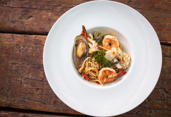 Spaghetti spicy seafood, Stir-fried Spicy Spaghetti Seafood Thai Style on Wooden Background.