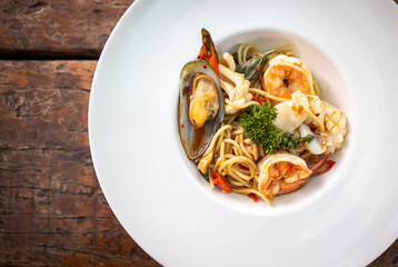 Spaghetti spicy seafood, Stir-fried Spicy Spaghetti Seafood Thai Style on Wooden Background.