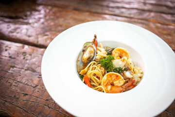 Spaghetti spicy seafood, Stir-fried Spicy Spaghetti Seafood Thai Style on Wooden Background.