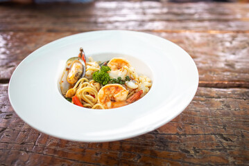 Spaghetti spicy seafood, Stir-fried Spicy Spaghetti Seafood Thai Style on Wooden Background.