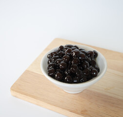 Tapioca Pearl , Bubble topping for tea or other beverage, in a cup, place on wooden table. Copy space