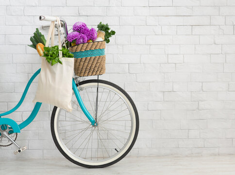 Bicycle with wildflowers and organic food over white bricks wall