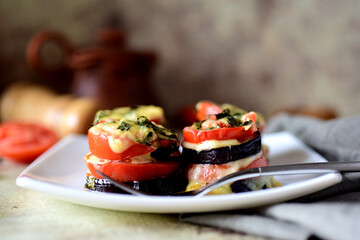 Eggplant parmegiano on a white plate on a gray background