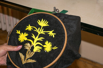 woman makes a gold embroidery