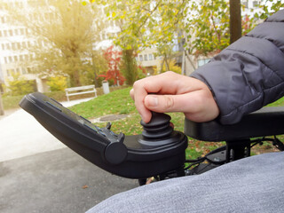 Close up of a disabled person hand driving electric wheelchair using joystick © 24K-Production