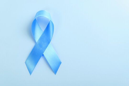 Blue ribbon on blue background, prostate cancer awareness concept. Copy space for text