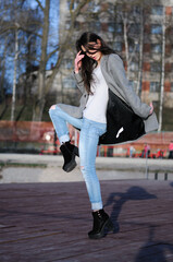 Full body portrait. Young brunette woman in blue jeans 