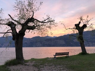 Fototapeta na wymiar Sunset over lake garda with a lonely bench