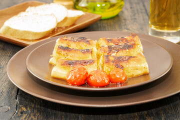 Just cooked pasta cannelloni in rustic stye on the wooden table. Side view.