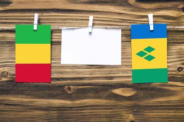 Hanging flags of Mali and Saint Vincent And The Grenadines attached to rope with clothes pins with...