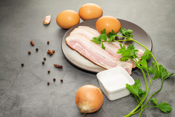 Ingredients prepared for cooking omelette with bacon.