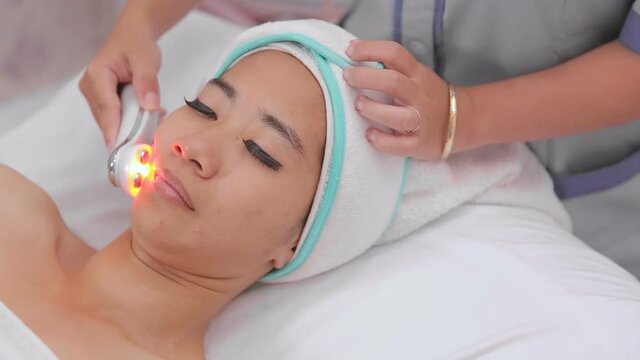 portrait asian woman getting treatment of collagen mask. rf skin tightening machine