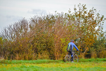 man doing mountain biking in the woods in autumn
