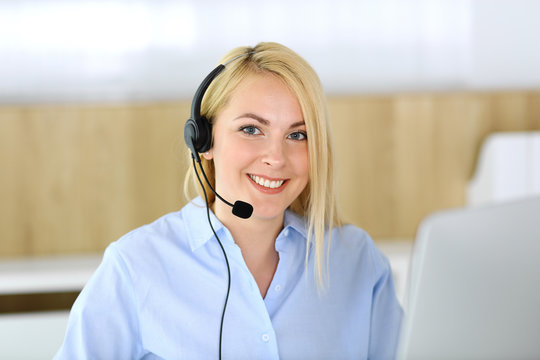 Call center. Blonde business woman sitting in headset at customer service office. Concept of telesales business or home office occupation