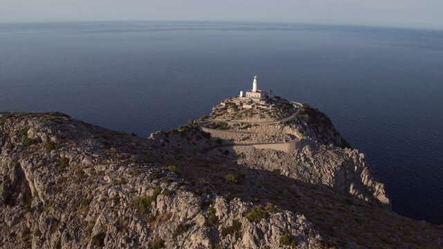 Aerial: Drone panning over mountain with lighthouse at Cap de Formentor against sea - Mallorca, Spain