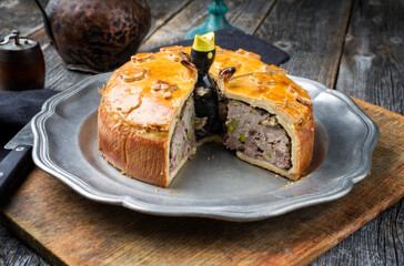 Traditional French Pate en croute with goose meat and liver as closeup on a pewter plate