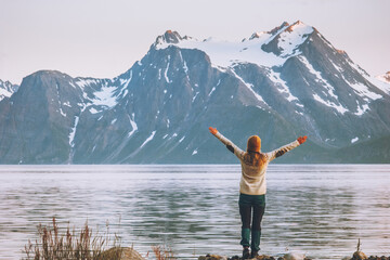 Woman traveler raised hands enjoying  Norway mountains view travel adventure vacations healthy...