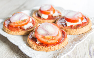 Bruschetta with tomato, cheese and onions on a wooden table