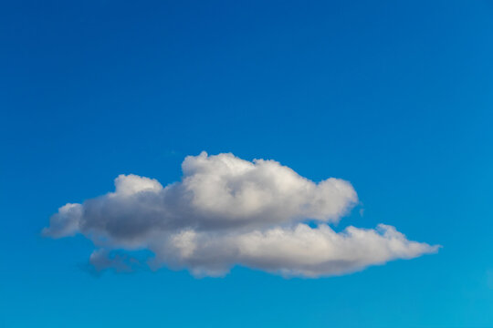 Two white fluffy clouds on a background of blue sky in sunny weather_