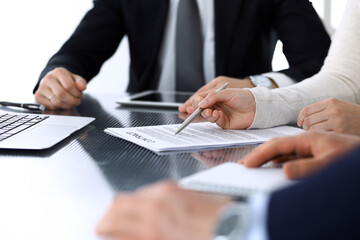 Business people discussing contract working together at meeting at the glass desk in modern office. Unknown businessman and woman with colleagues or lawyers at negotiation. Teamwork and partnership