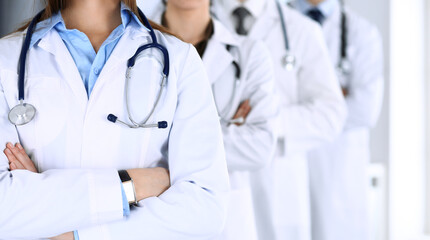 Group of modern doctors standing as a team with arms crossed in hospital office. Physicians ready...