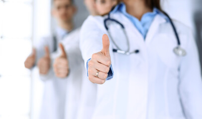 Group of modern doctors standing as a team with thumbs up in hospital office. Physicians ready to examine and help patients. Medical help, insurance in health care, best desease treatment and medicine