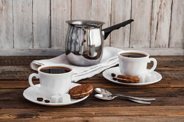 Coffee on a wooden table in white mugs