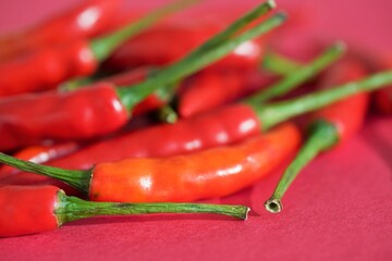 red chili peppers on scarlet background