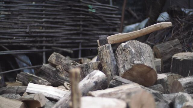 Preparation of firewood chocks for chopping outdoors. Oak firewood block is thrown in slow motion to be chopped with axe for winter storing in a stack.