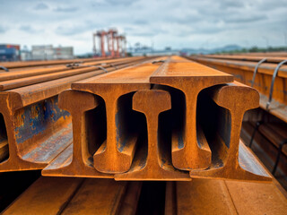 Close up bundle of steel rails are stacking in outdoor yard.