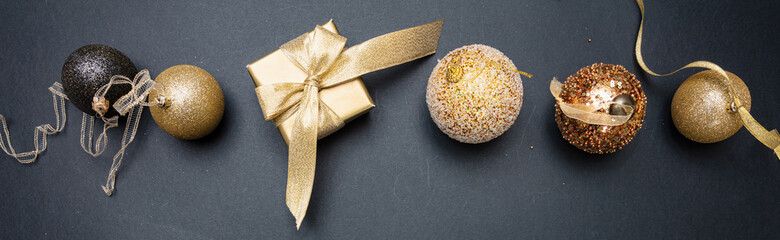 Xmas present and bauble shiny gold color against grey black background