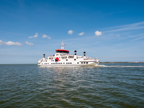 Car ferry boat with passengers sailing on Waddensea from Frisian island Ameland to Holwerd in Friesland, Netherlands