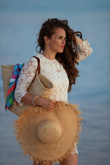 modern woman on seashore at sunset looking into distance