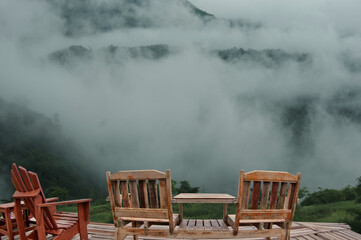 Wooden chair and misty mountains in the rainy season - 299956583