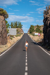 young Female walking on the road in Teide volcano crater