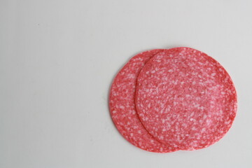 slices of salami on white background