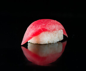 Sushi nigiri with tuna on black background.