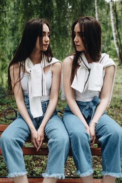 Portrait of Two Young Brunette Twins Sisters Dressed Alike in Jeans and White T-shirt, Best Friends Forever Concept