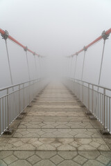 Hanging bridge vanishing in fog